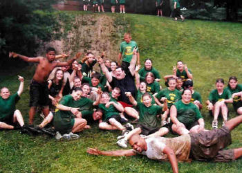 Kids rolling down a muddy hill